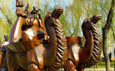 公園景區擺放的兩只馱著小孩的玻璃鋼仿銅創意駱駝雕塑