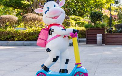 幼兒園一只騎車(chē)背包的玻璃鋼卡通牛雕塑